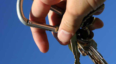 A pair of keys dangles from the hand of a new driver.